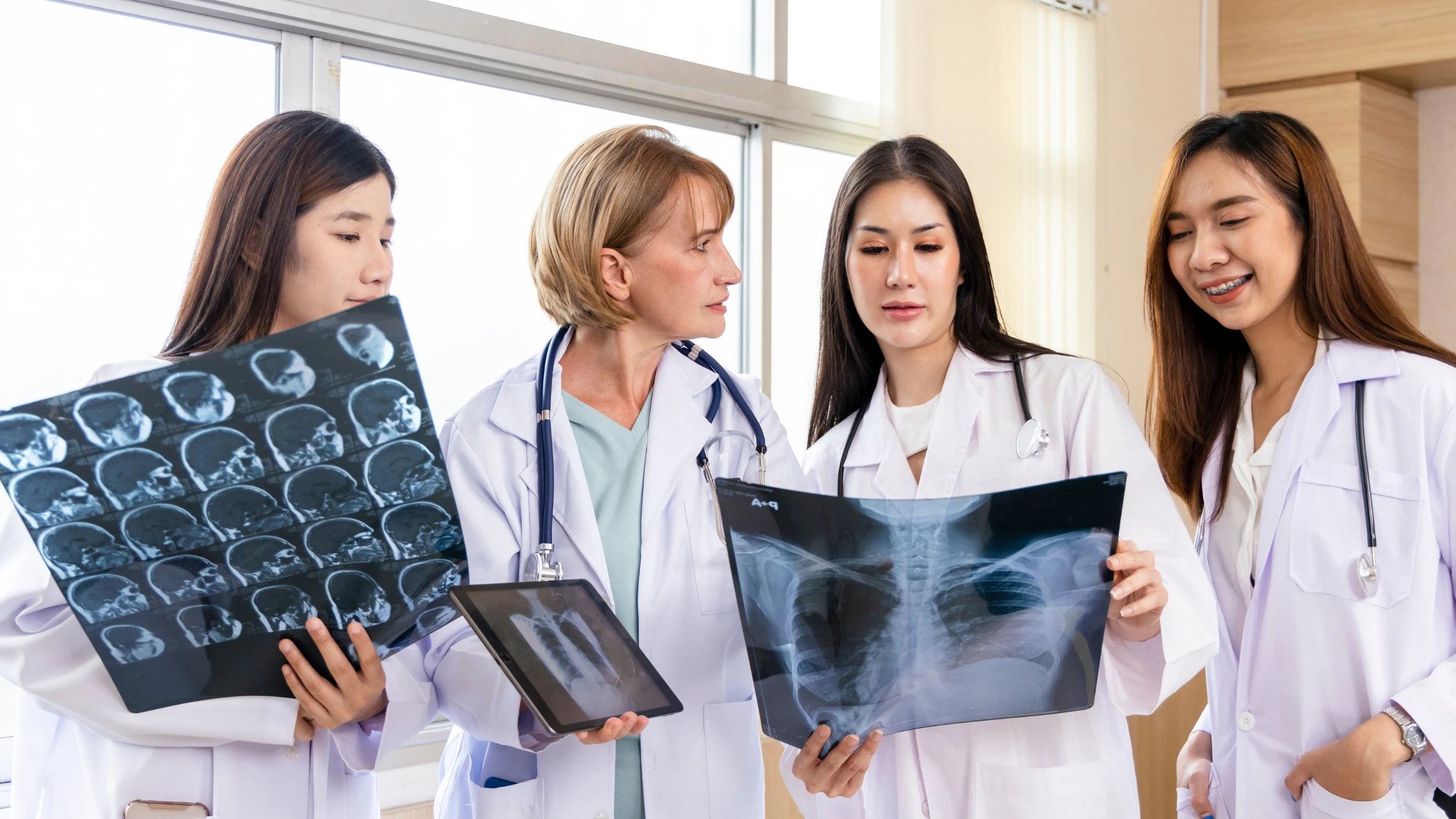 A group of medical students on clinical clerkships examining x-rays.